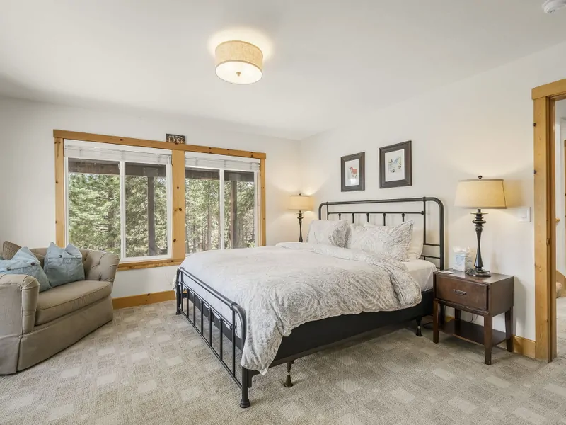 Lower Floor: Primary Bedroom with a King-sized bed, oversized chair, flatscreen TV, and dresser and offers a private four-piece ensuite