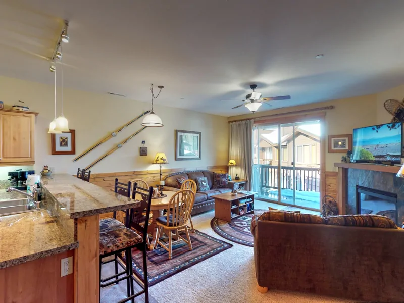 Living room with nearby kitchen and door to deck: Truckee Cinnabar Vacation Retreat